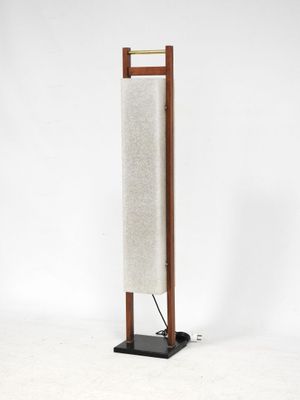 un grand lampadaire en bois muni d'un abat-jour en tissu blanc