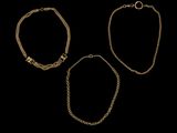un ensemble de trois bracelets en or sur fond noir