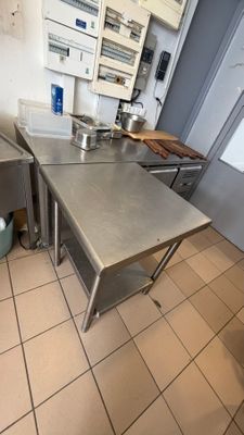 a stainless steel table in the middle of a kitchen