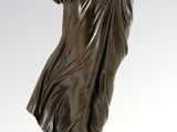 a bronze statue of a woman holding a bird on top of a ball