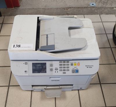 a printer that is sitting on the floor next to a bag