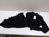 a black shirt on a white table with a tag on it