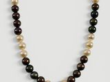 un collier de perles noires et blanches sur fond blanc