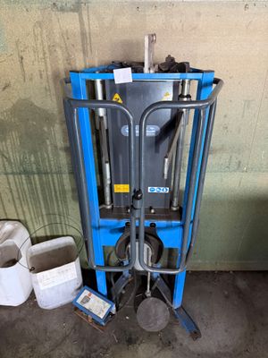 une photo d'un chariot élévateur bleu dans un garage
