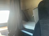a bed in the back of a bus with a curtain