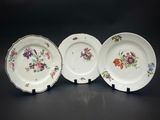 trois assiettes à motifs floraux posées sur une table