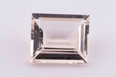un gros plan d'un diamant à facettes posé sur une surface blanche