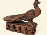 une sculpture en bois représentant un oiseau perché sur un morceau de bois