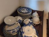 beaucoup d'assiettes et de bols bleus et blancs sur une étagère