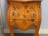 une petite commode en bois ornée d'un motif floral