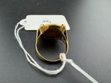 an image of a gold ring on a string with a tag