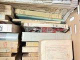 many books stacked on top of each other in a box