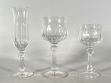 three wine glasses sitting next to each other on a table