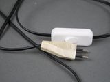 a white device plugged into a black cord on a table