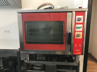 a red oven sitting on top of a stove in a kitchen