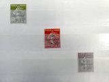 quatre timbres différents posés sur une feuille de papier posée sur une table