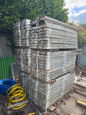 a pile of wood stacked on top of each other in a yard