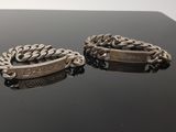deux bracelets en argent avec une chaîne, sur un fond noir