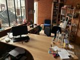 un bureau sur lequel se trouve un ordinateur, près d'une fenêtre