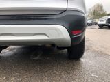 a close up of a car ' s rear end with a cat underneath it