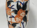 a white vase with blue and orange designs on it