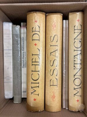 three books in a box on a shelf next to each other