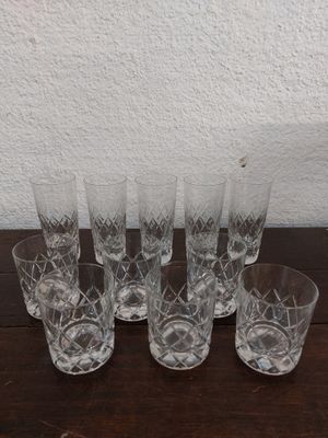 six verres posés sur une table, avec un mur blanc en arrière-plan