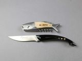 two knives and a fish shaped bottle opener on a table