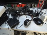 a computer desk with a lot of wires and headphones