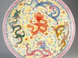 an image of a yellow and red plate with dragon designs on it