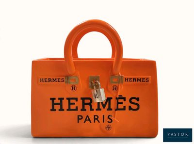 an orange hermes paris handbag with a logo on the front