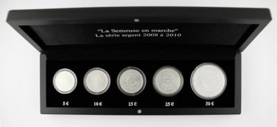 three silver coins are in a black box on a white surface