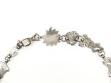 silver bracelet with flowers and leaves on it on a white background