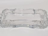 a clear glass ashtray sitting on a white surface