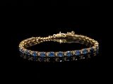un bracelet en or orné de pierres bleues sur fond noir
