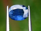 un gros plan sur une pierre bleue tenue par une pince