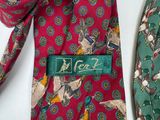 two ties with different designs on them on a table