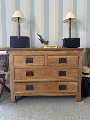a wooden chest of drawers with a laptop on top of it