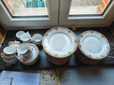 de nombreuses assiettes et tasses posées sur une table près d'une fenêtre