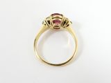 a close up of a gold ring with a ruby stone