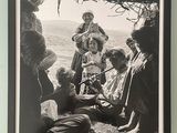 black and white photograph of a group of people sitting under a tree