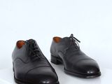 a pair of black shoes with laces on a white surface