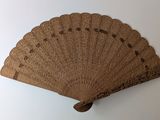 a brown fan on a white wall with a white background