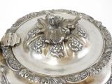 a silver plate with a lid on a white table