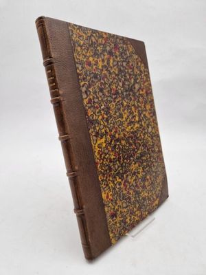 an old book with a brown cover sitting on top of a white surface