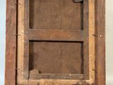 an old wooden picture frame with a white button on it
