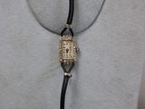 an image of a woman ' s necklace with a watch attached to it