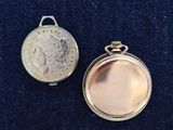 two silver lockes on a blue cloth with a coin in the background