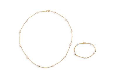 un ensemble composé d'un collier et d'un bracelet en or sertis de perles, sur fond blanc