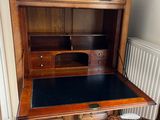 a wooden desk with a black top and a chair in front of it
